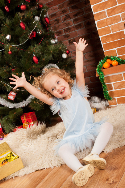 Little girl sitting near Christmas tree - Valokuva, kuva