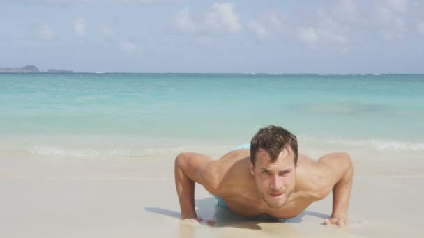 man model training pushups on beach - Materiał filmowy, wideo