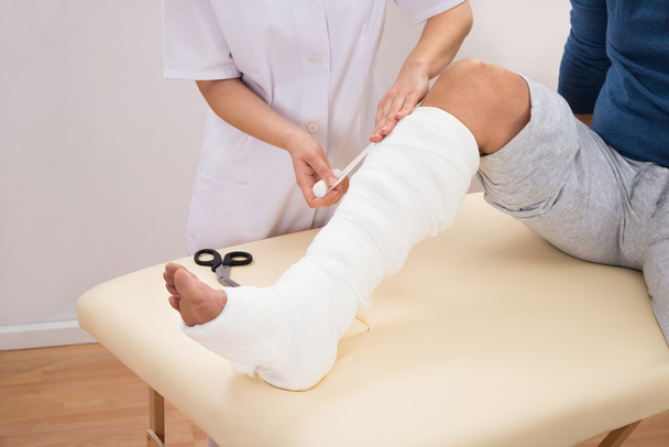 Doctor Bandaging Patient Leg - Foto, imagen