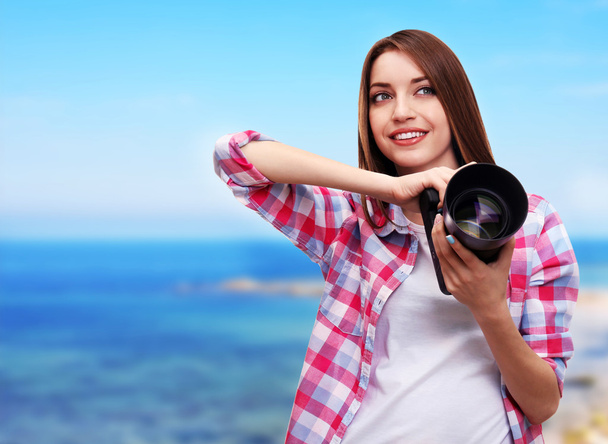 Young female photographer taking photos on nature background - Zdjęcie, obraz