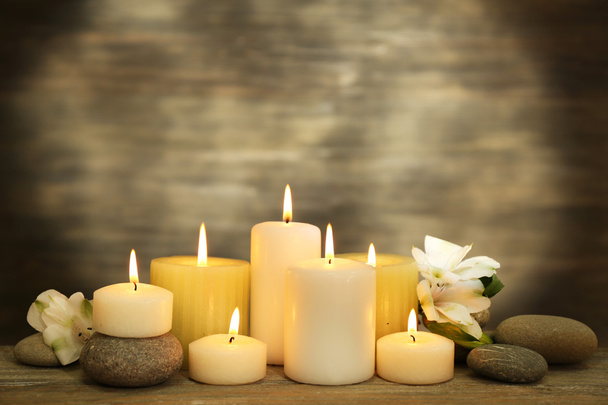 Beautiful composition with candles and spa stones on wooden background - Zdjęcie, obraz