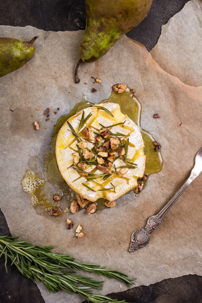 Delicious baked camembert with honey, walnuts, herbs and pears - Photo, Image