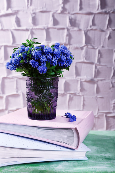 Beautiful bouquet of muscari - hyacinth in vase on wall background - Fotó, kép