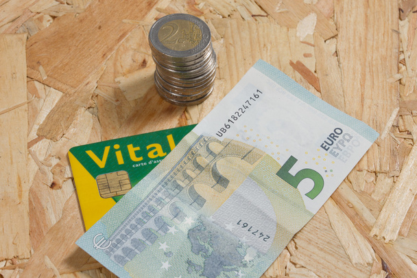 Concepto de cuidado de la salud caro con monedas, billetes y tarjeta sanitaria francesa
 - Foto, imagen