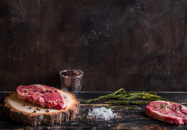 Syrové maso šťavnaté steaky na tmavé dřevěné pozadí připraveno k pečení - Fotografie, Obrázek