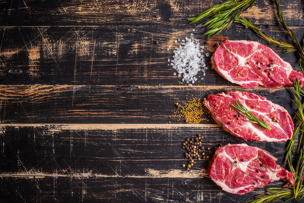 Raw meat steak on dark wooden background ready to roasting - Photo, Image