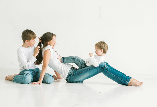 mother with children in jeans on white backgroun - Φωτογραφία, εικόνα