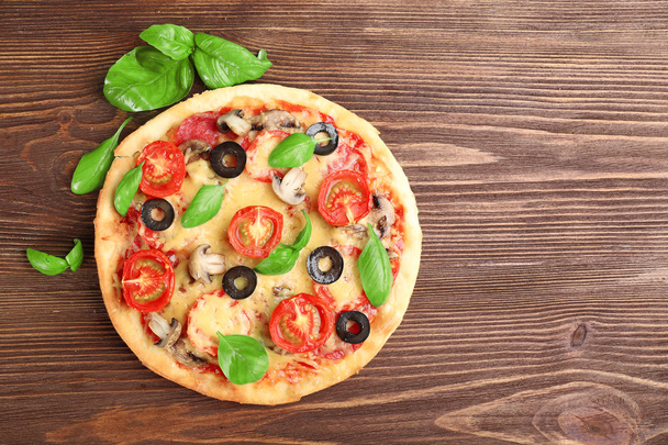 Tasty pizza with vegetables and basil on wooden background - Zdjęcie, obraz