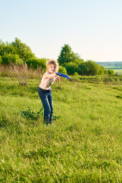 Tyttö pelaa frisbee puistossa
 - Valokuva, kuva