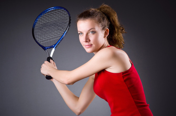 暗い背景に女性のテニス選手 - 写真・画像