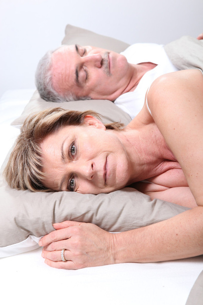 Mature couple laid in bed - Фото, зображення