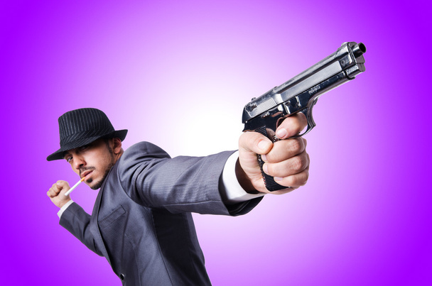 Businessman with gun against the gradient - Foto, Imagen