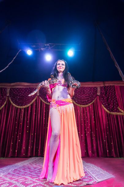Dançarina de barriga exótica em pé no palco com cobra
 - Foto, Imagem