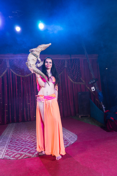Bailarina exótica del vientre sosteniendo pequeño cocodrilo
 - Foto, Imagen