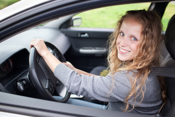 Pretty young woman driving her new car - Photo, image