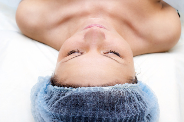 Молода біла жінка лежить, отримуючи масаж голови
 - Фото, зображення