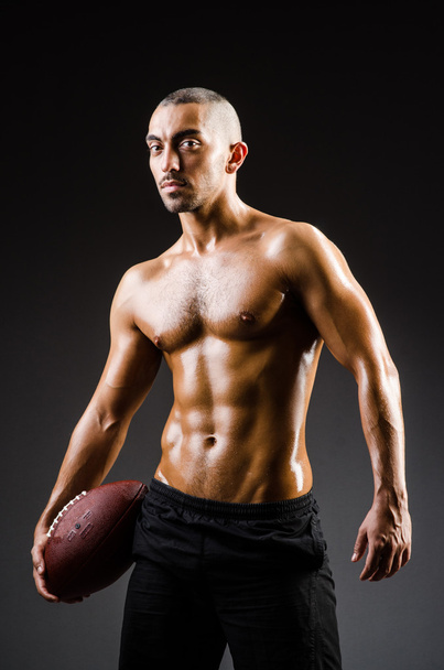 Muscular football player with ball - 写真・画像