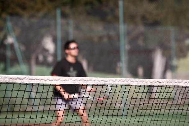 Tennis player in action (selective focus, focus on the net) - Zdjęcie, obraz