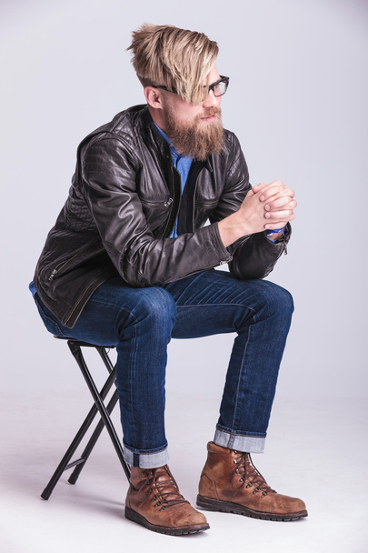 hipster man holding his hands together while sitting - Photo, Image