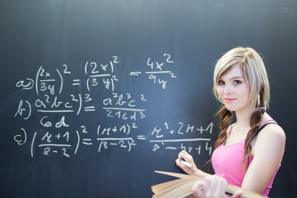 Pretty young college student writing on the chalkboard - Foto, Imagen