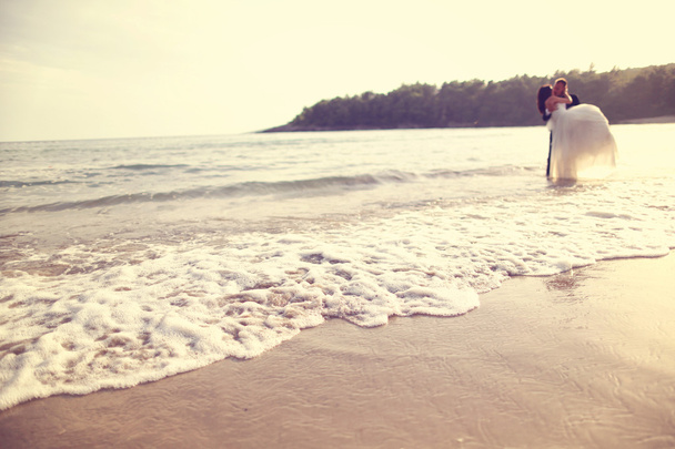 Bride holding his bride at the beach - Φωτογραφία, εικόνα