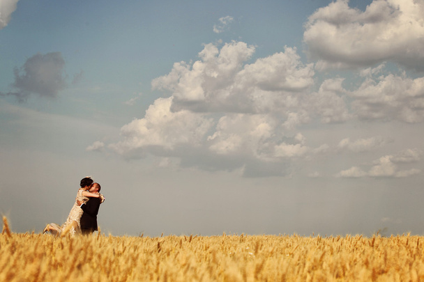 Bride and groom in field - Фото, зображення