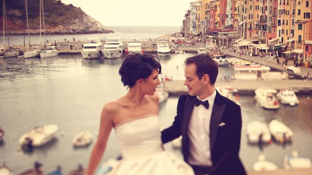 Bride and groom on bridge with boats in background - Photo, image