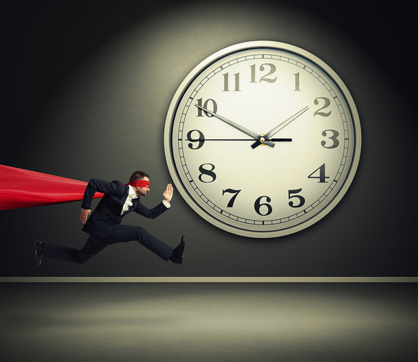 superman corriendo contra el gran reloj blanco
 - Foto, Imagen