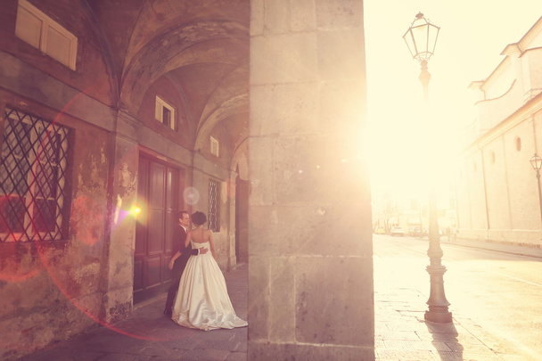 Bride and groom at sunset in old city - Foto, Bild