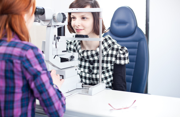 Optometry concept - pretty young woman having her eyes examined - Fotoğraf, Görsel