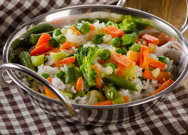 Rice with vegetables on  wooden table. - Foto, afbeelding