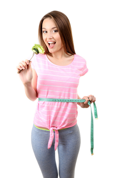 Healthy young woman with vegetables on fork and measuring tape isolated on white - Foto, Imagen