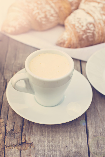 Eine Tasse Kaffee "Espresso" und Croissant auf dem Holztisch. Tonne Foto. - Foto, Bild
