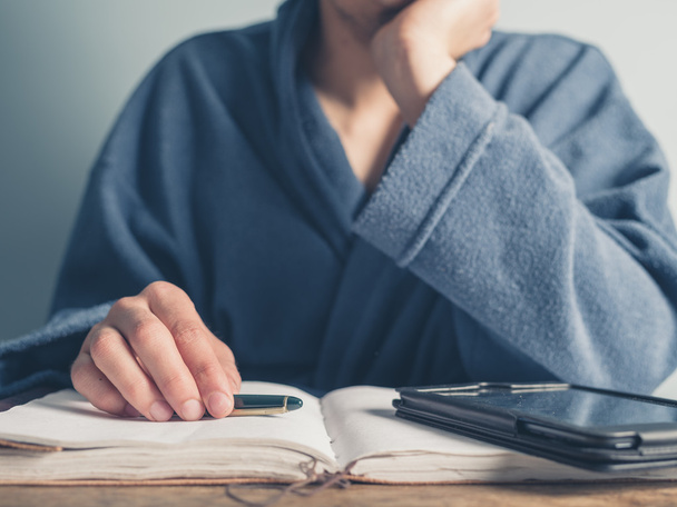 Man in bathrobe using table and taking notes - Photo, Image