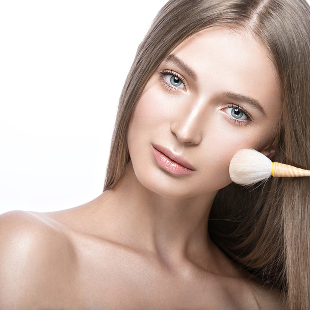 Beautiful young girl with a light natural make-up and beauty tools in hand.  - Foto, imagen