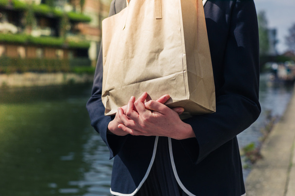 Woman with paper bag by canal - Photo, Image