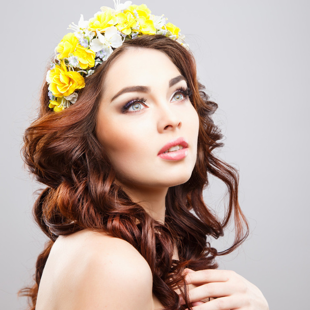 Close-up portrait of beautiful young woman with perfect make-up and hair-style with flowers in hair - Photo, image