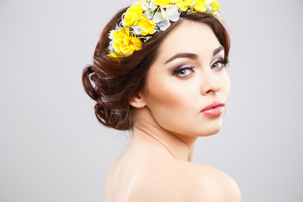 Close-up portrait of beautiful young woman with perfect make-up and hair-style with flowers in hair - Фото, изображение