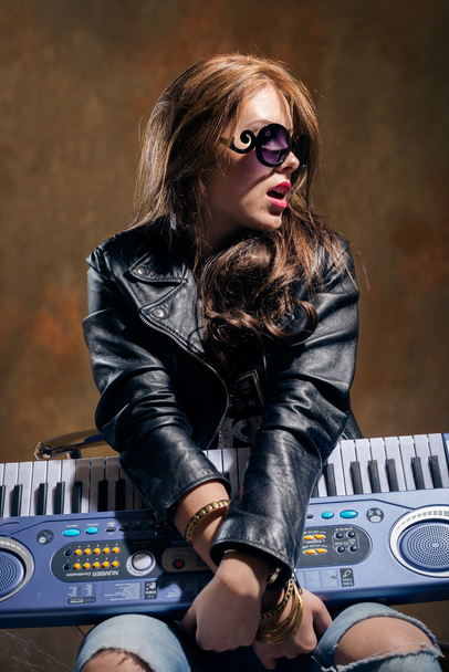 woman in  sunglasses  holding synthesizer - Foto, Imagen