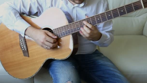 Gyakorlom a gitározást. Jóképű fiatalember gitározik. - Felvétel, videó