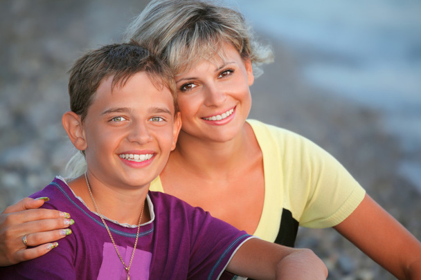 Smiling boy and young woman on beach in evening - Foto, Bild