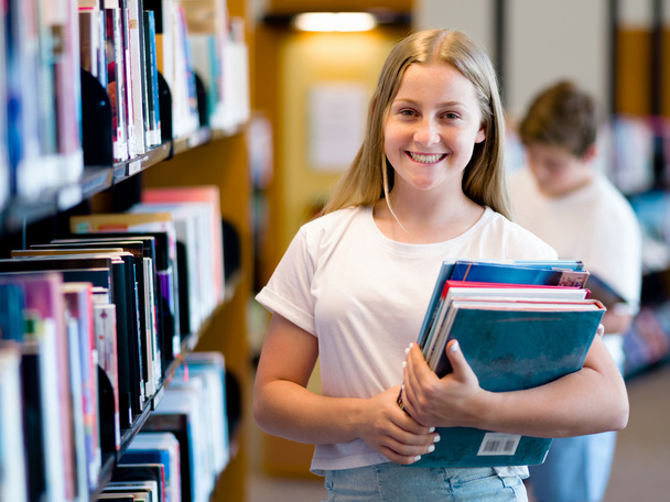 Teenage girl in library - Foto, imagen