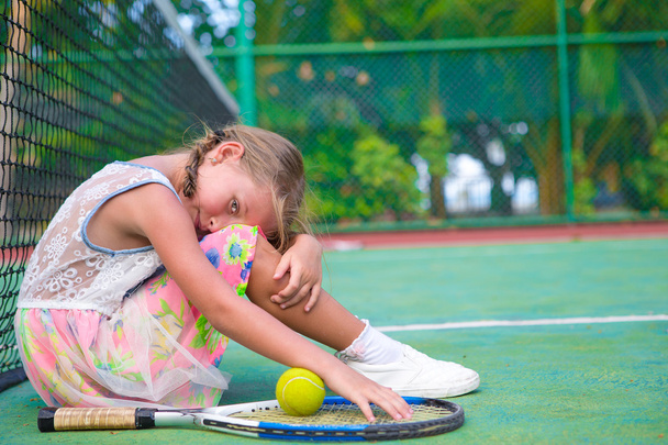 Little girl trying to play tennis on outdoor court - Φωτογραφία, εικόνα