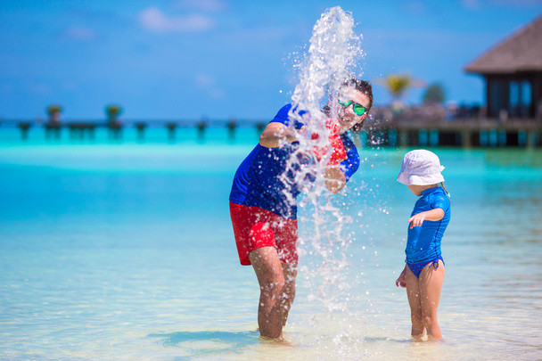 Pai feliz e filha se divertem na praia tropical
 - Foto, Imagem