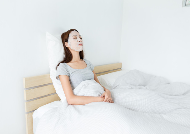 Femme utilisant un masque en papier sur le visage
 - Photo, image
