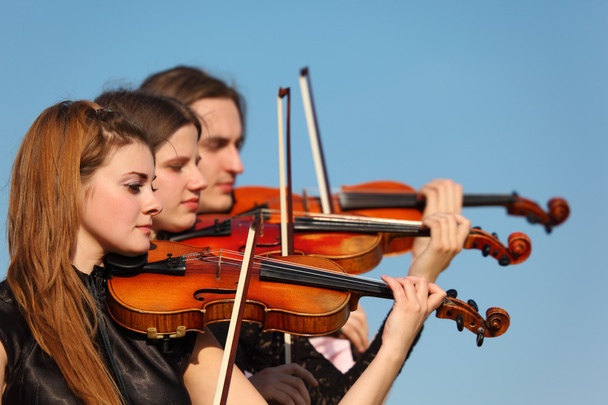 Trio of violinists plays against sky - Foto, Imagem