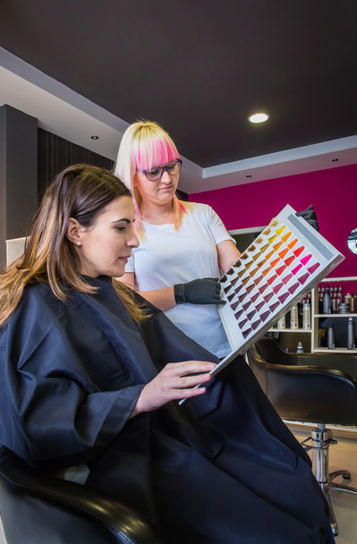 Жінка дивиться з перукарем палітру фарби для волосся
 - Фото, зображення