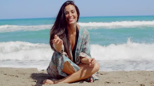Красива дівчина сидить на пляжі - Кадри, відео