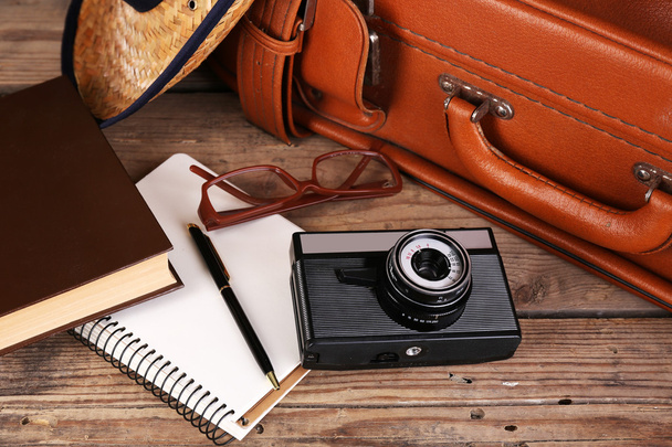 木製の背景の旅行のためのスーツケースをパッキング - 写真・画像