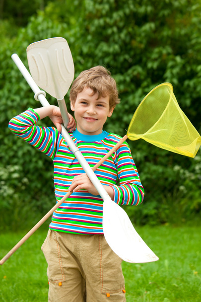 O menino com remos e uma rede ao ar livre
 - Foto, Imagem